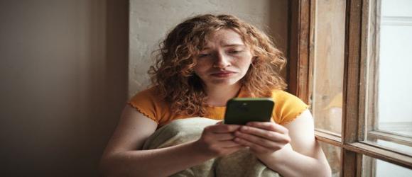 worried person looking at her phone